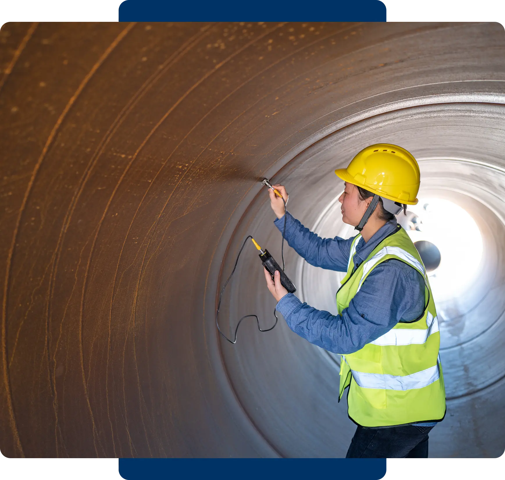 Engineer inspecting the interior of a large industrial pipe.